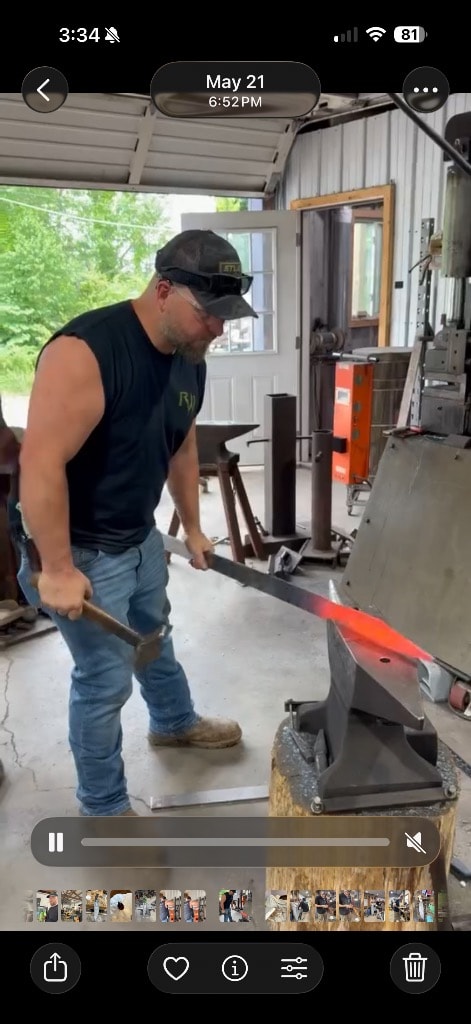 Blacksmith forging a knife blade at the anvil